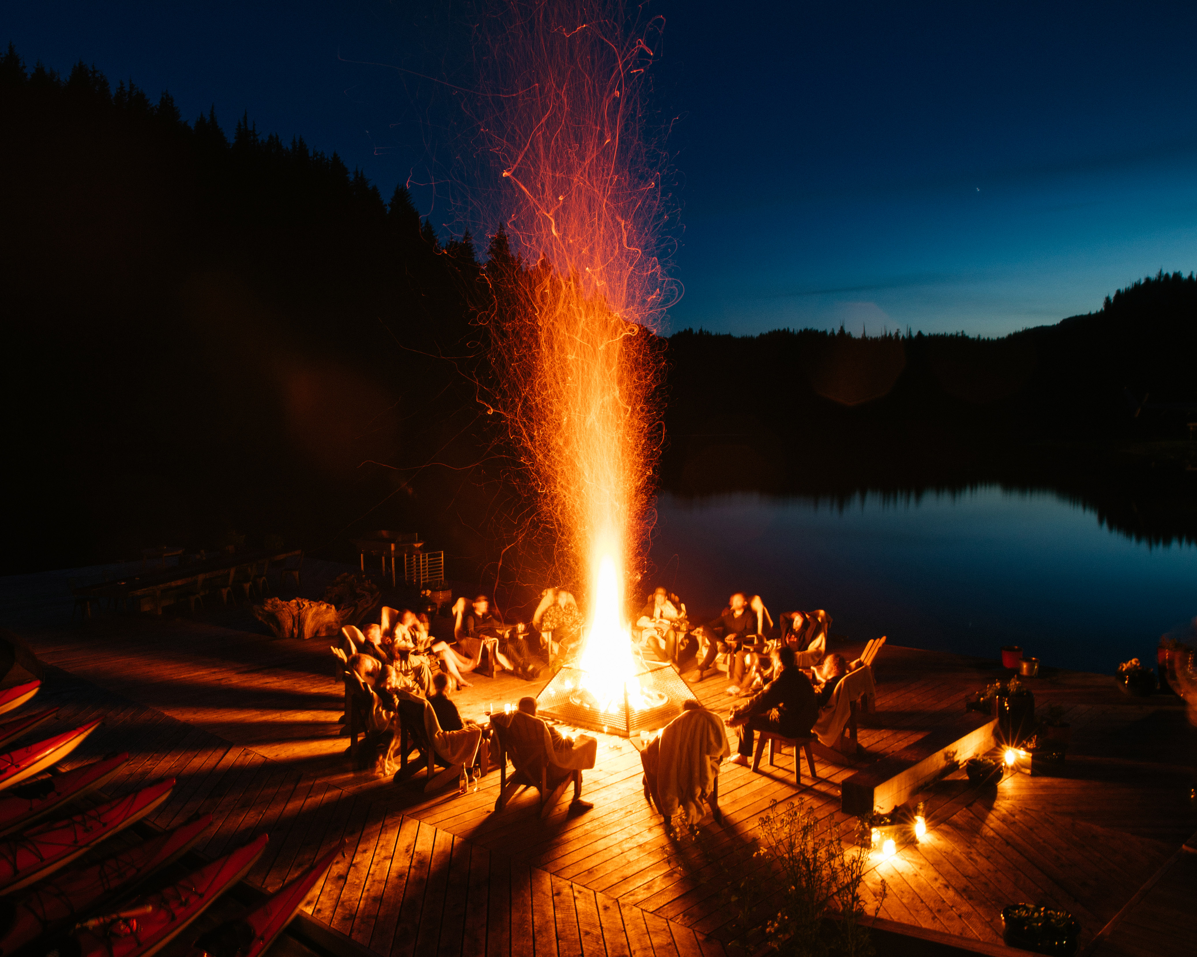 Luxury Family Vacations: a bonfire by a lake at night. 
