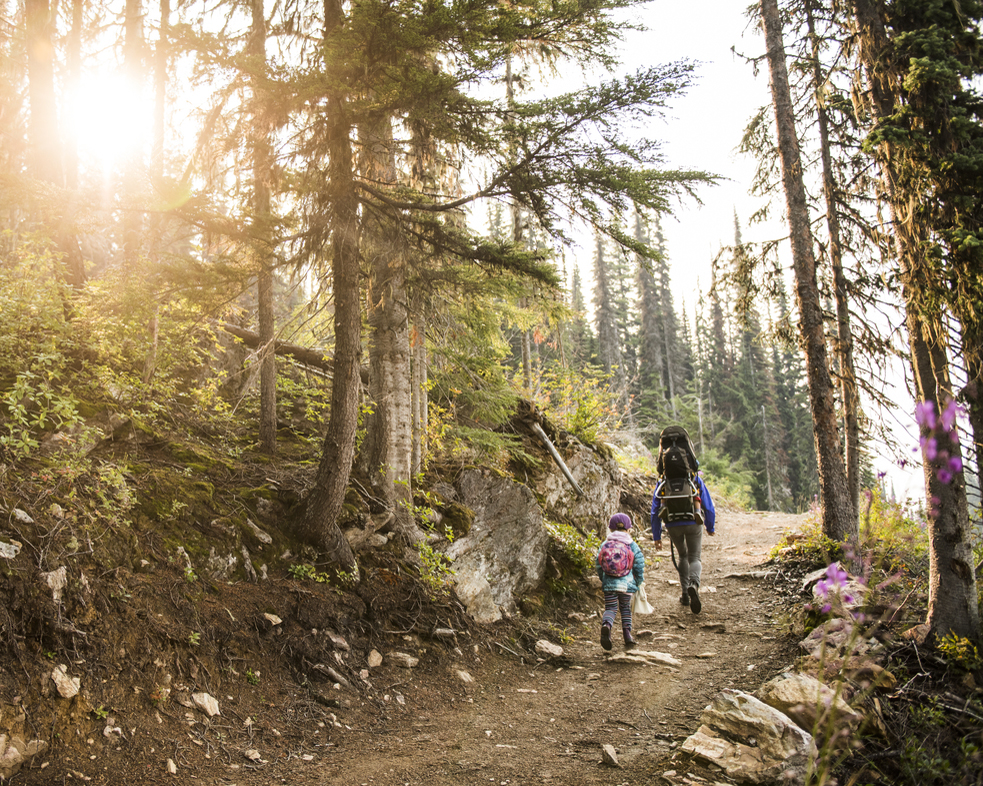 Luxury Family Vacations: a father and his daughter walk a mountain trail in the sun.