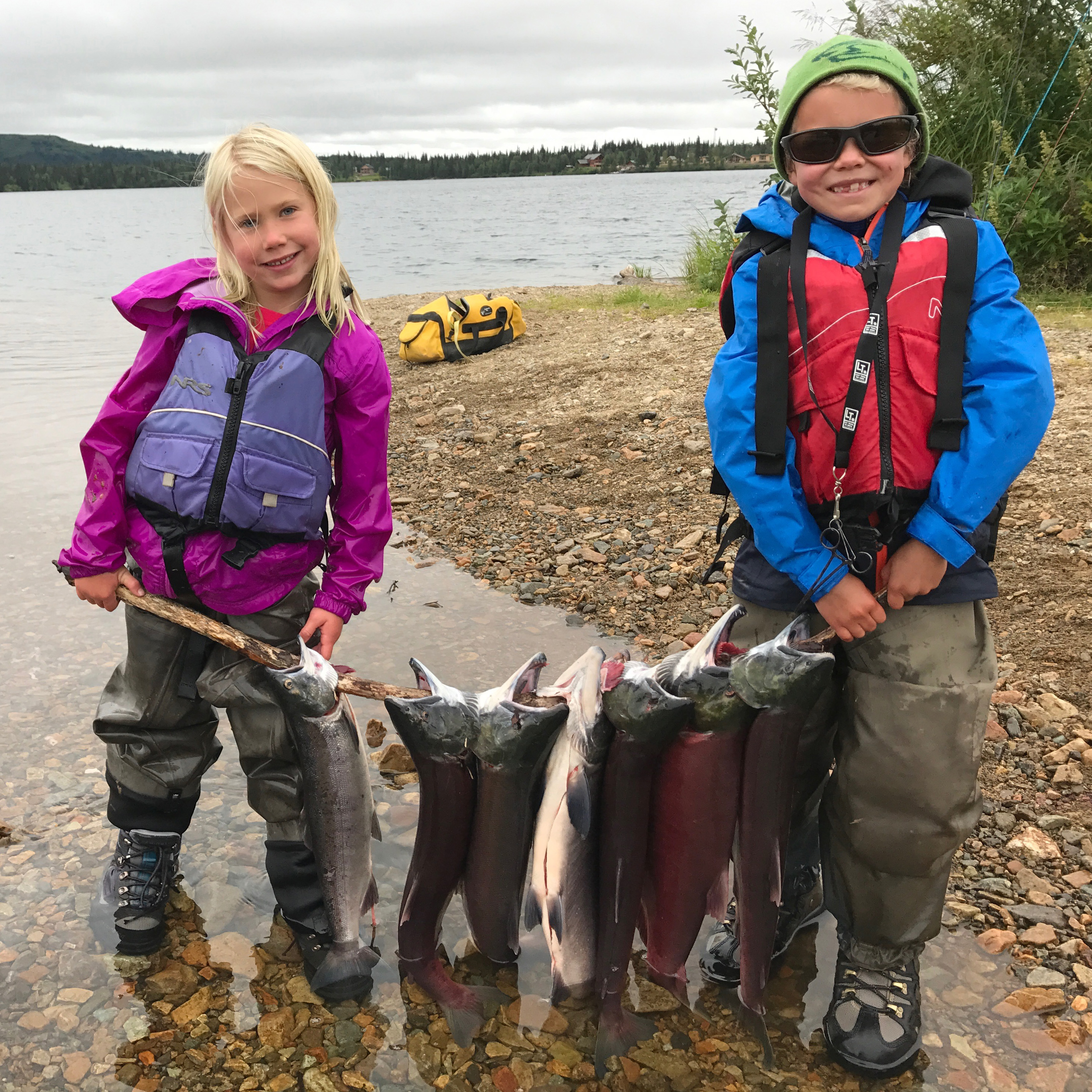 Best fishing trips: Children with fish by the river in Alaska