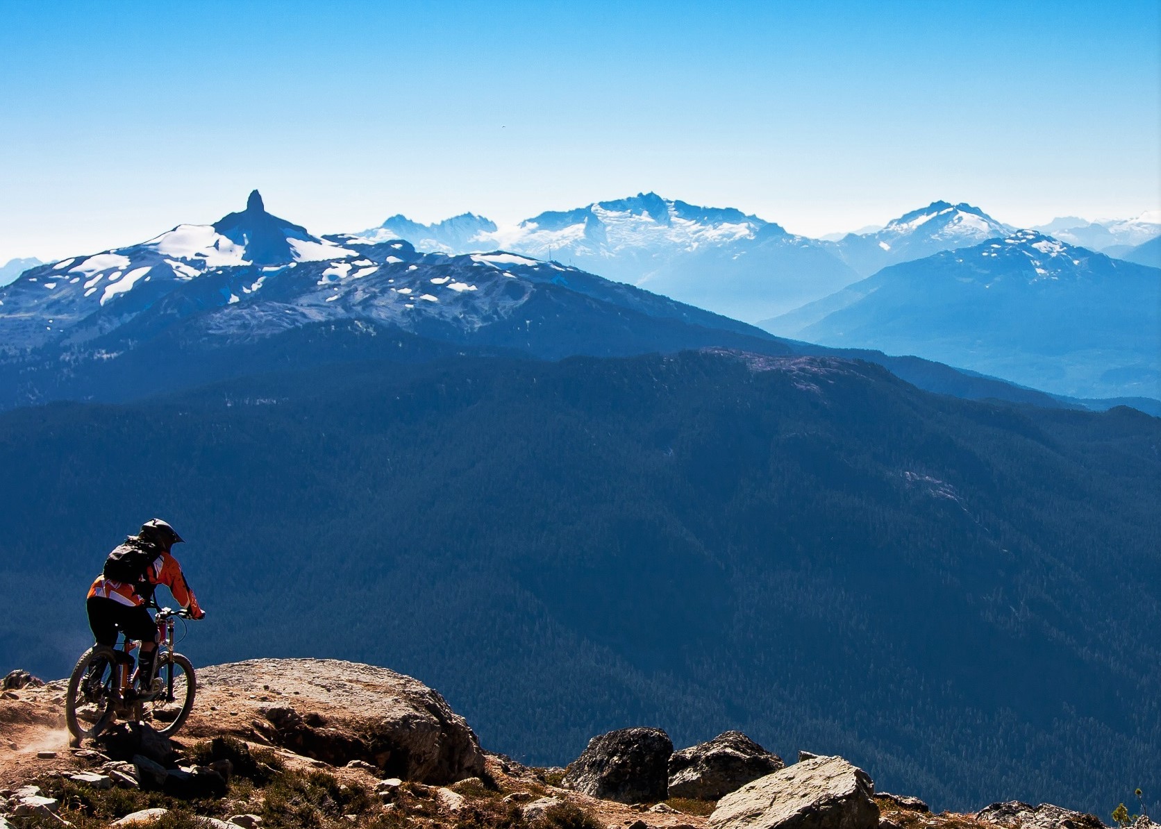 Whistler in the summer: person mountain biking with the Tusk mountain in the background.