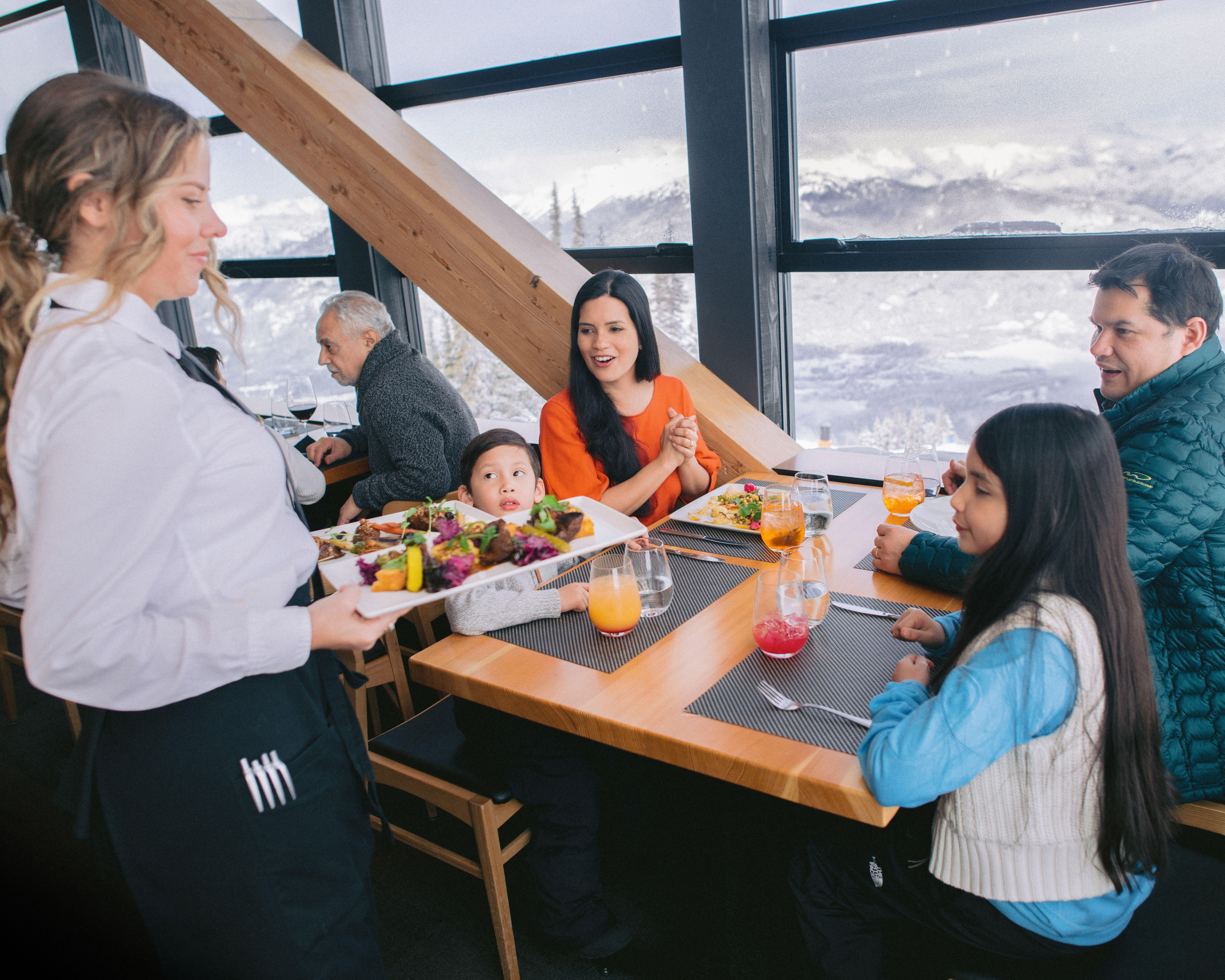 Whistler Skiing Vacations: A family being served lunch at the top of a mountain.