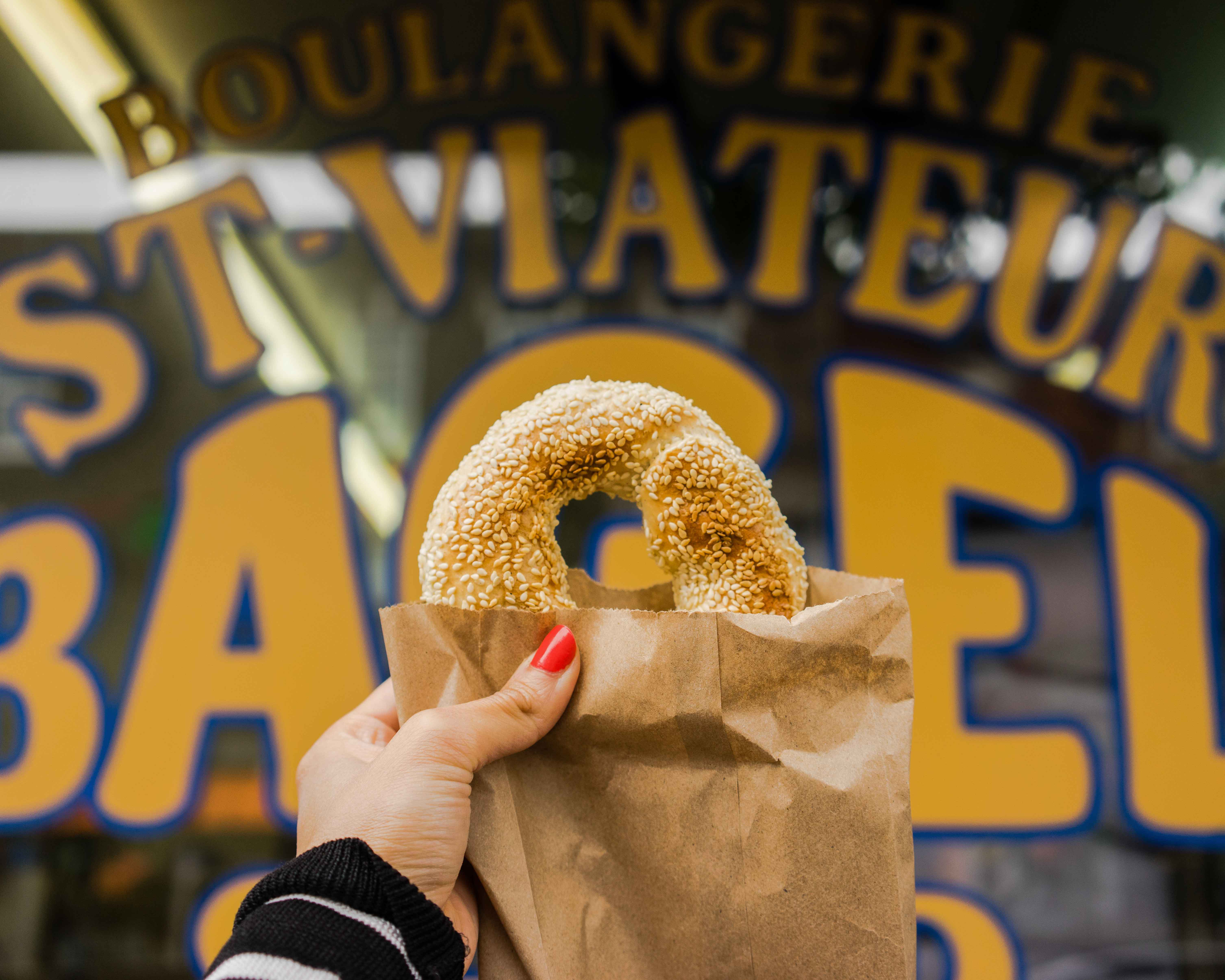 Montreal Travel Guide: holding up a bagel to the camera in Montreal.