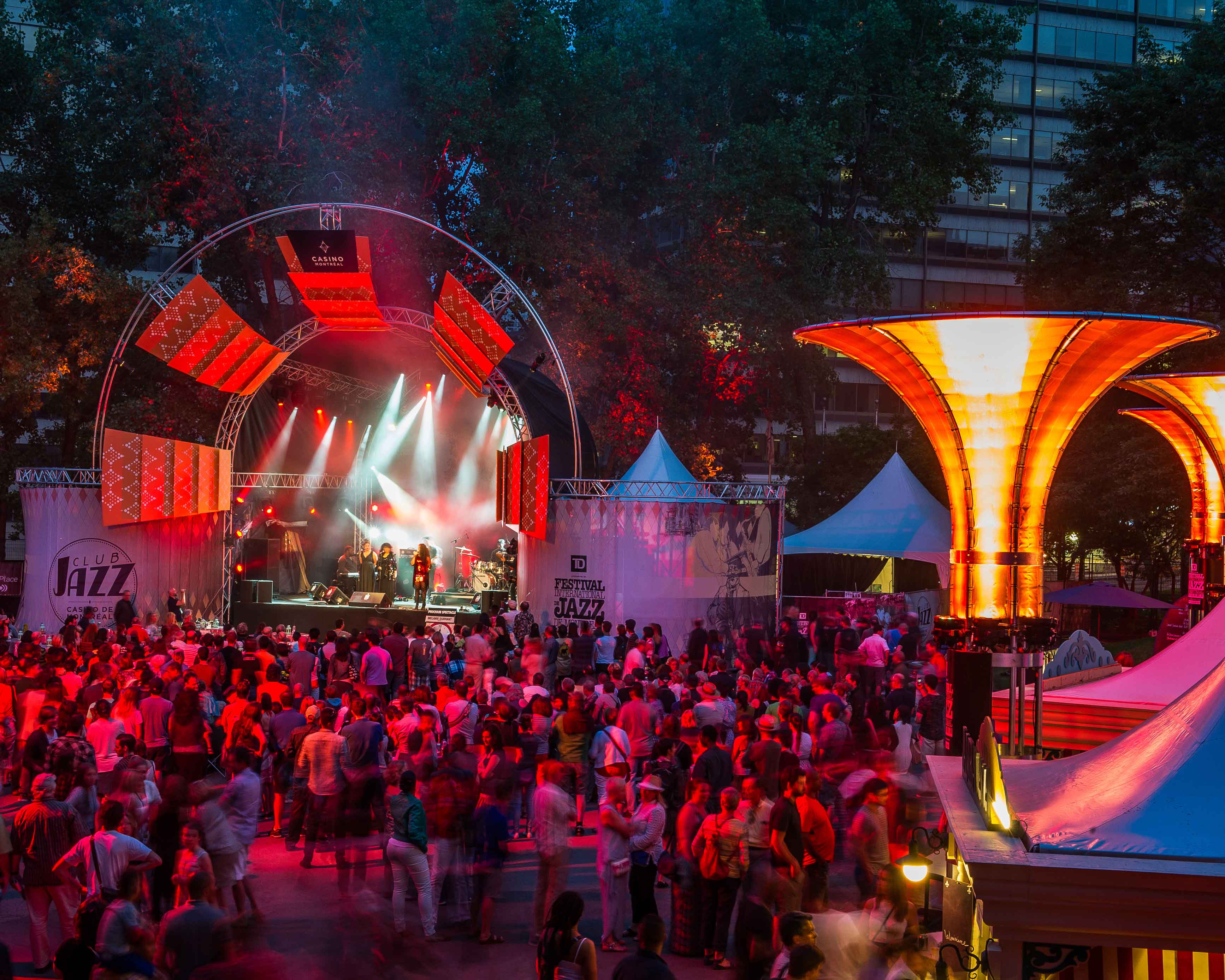 Montreal Travel Guide: a lit up stage performing to crowds of people.